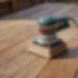 An orbital sander ready for use on a wooden deck